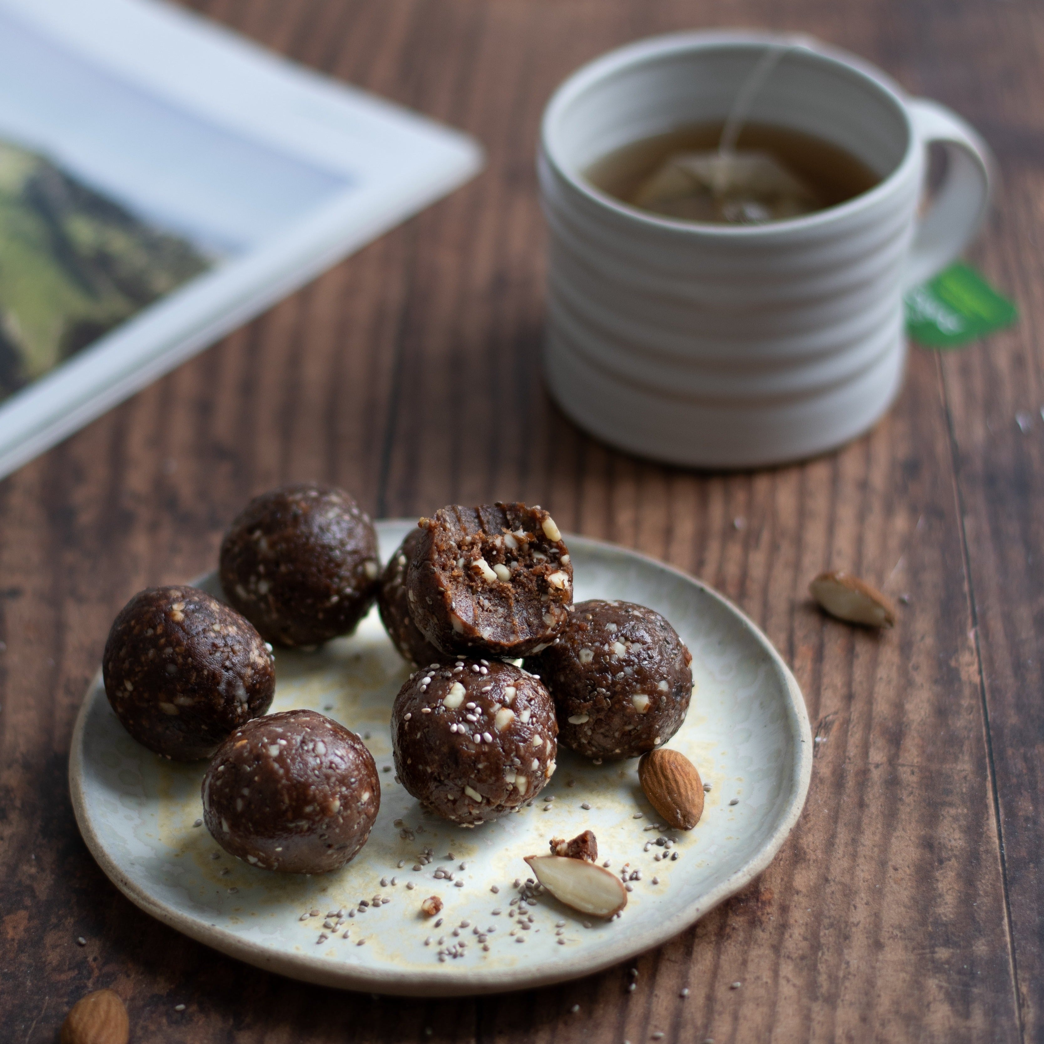 Baobab & Cacao Energy Balls on a plate next to a cup of herbal tea