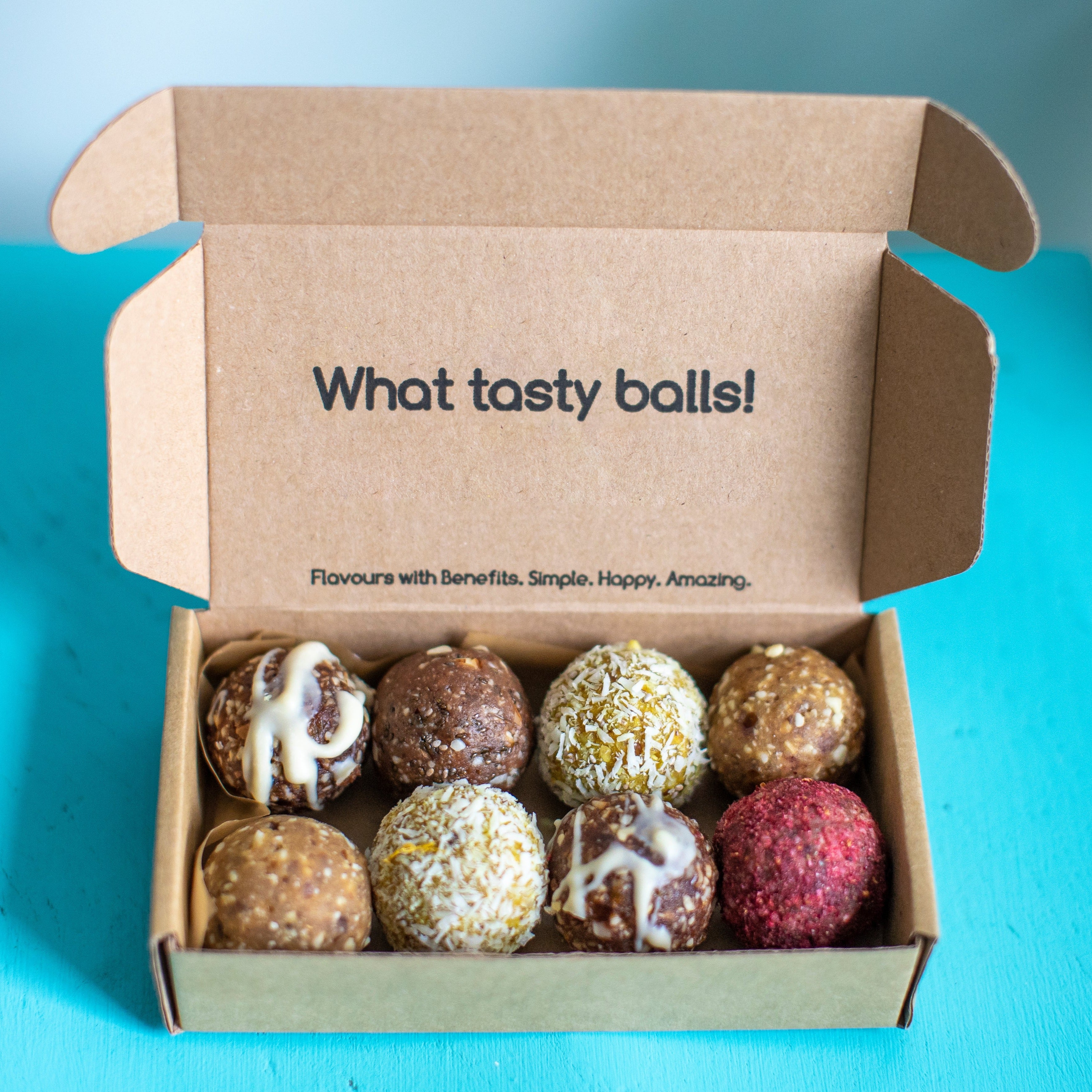 A box of mixed energy balls on a blue background