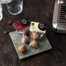 A pack of 2 Ginger Cashew Energy Balls and a pack of 2 Baobab & Cacao energy balls on a plate 