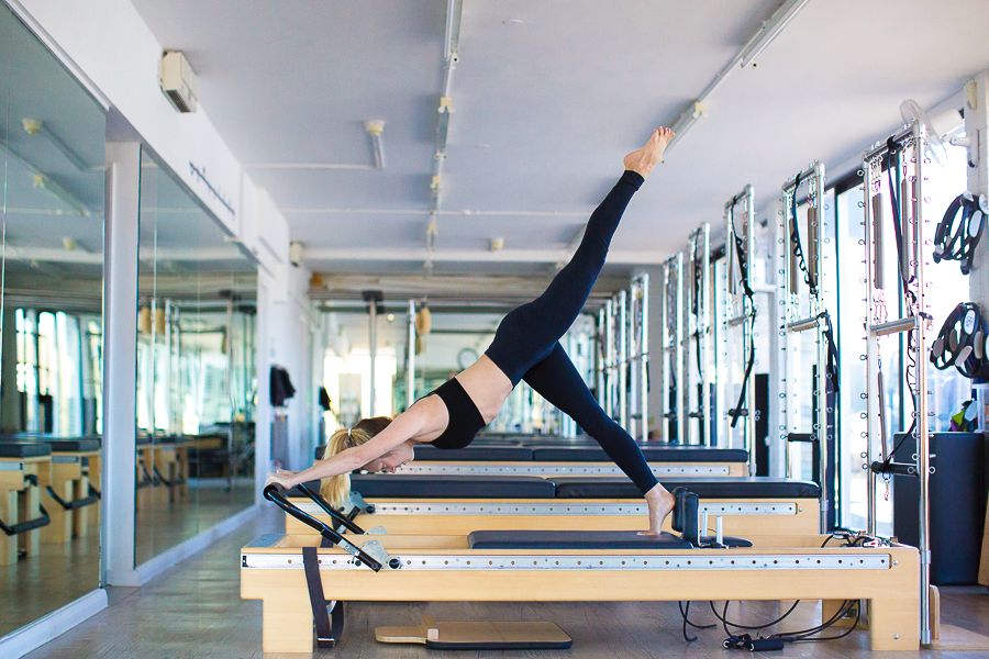 Claire stretching on a reformer pilates machine